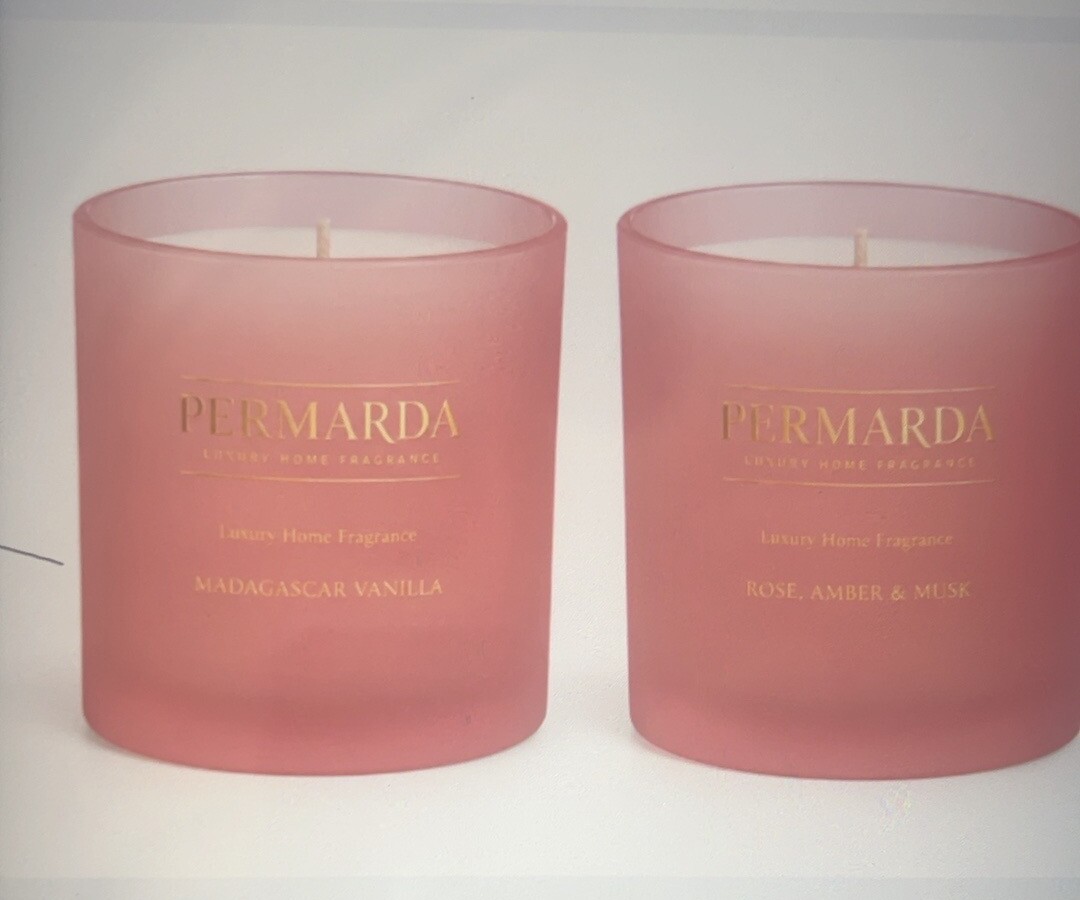 Two frosted pink PERMARDA candle jars in Madagascar Vanilla and Rose, Amber and Musk fragrances